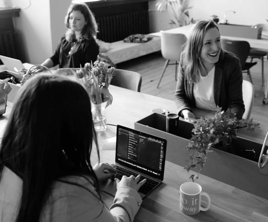 Three women writing code.